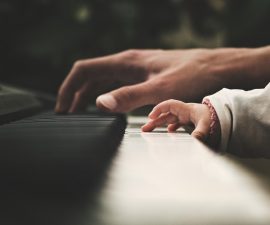 Adult and baby playing the piano