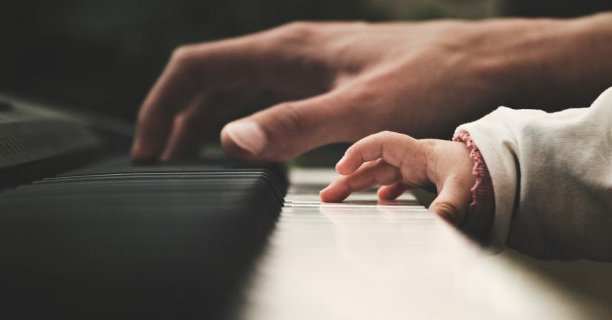 Adult and baby playing the piano