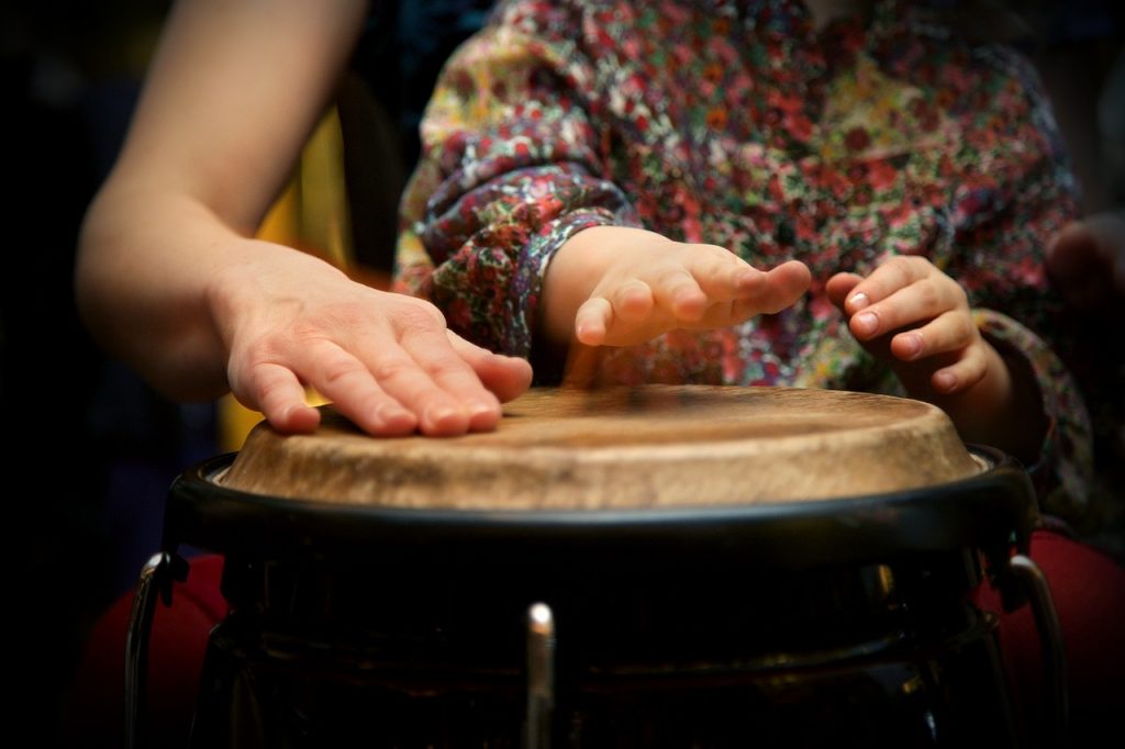 Adult and child beating the drum